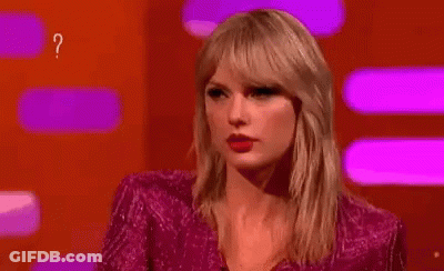 Woman In Pink Dress Surrounded By Question Marks Making Funny Face GIF