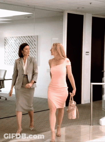 Woman In Pink Dress Walking Beside Grey Suit GIF