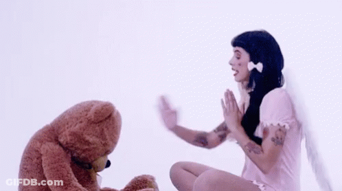 Woman In Pink Dress Waving To Teddy Bear GIF
