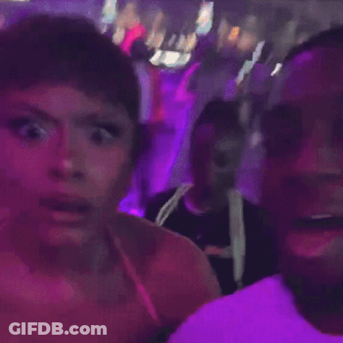 Woman In Pink Dress With Purple Lights In Dark Room GIF