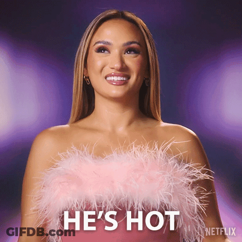 Woman In Pink Feathered Top Saying He's Hot GIF