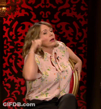Woman In Pink Floral Shirt Before Red And Black Wall GIF