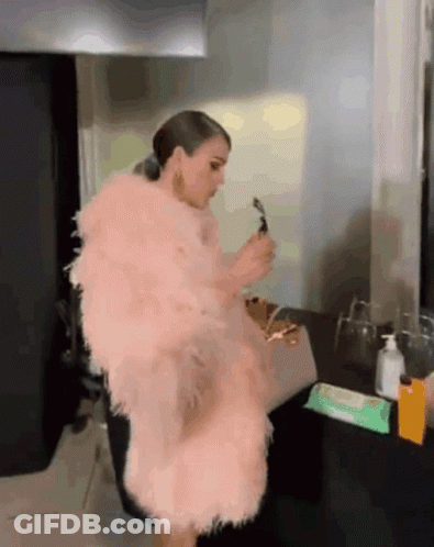 Woman In Pink Fur Coat Before Mirror GIF