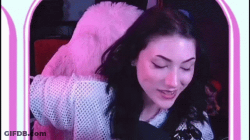 Woman In Pink Furry Jacket Eyes Closed At Mirror GIF