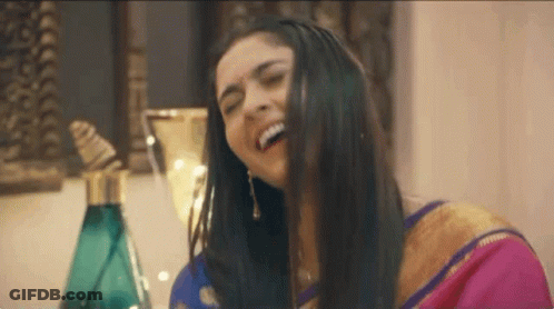 Woman In Pink Gold Sari Laughing Hair In Mouth GIF