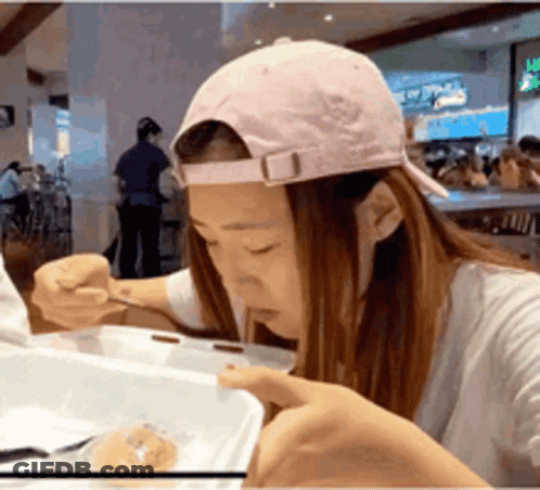 Woman In Pink Hat Eating From Container GIF