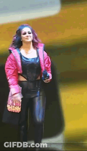 Woman In Pink Jacket And Black Pants Walking Down Street GIF