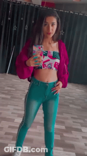 Woman In Pink Jacket And Blue Jeans Taking Selfie GIF