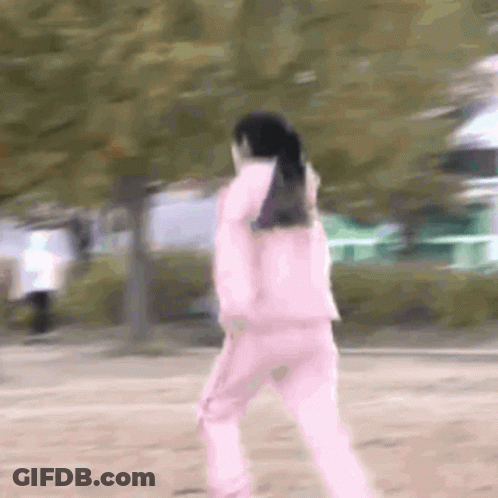 Woman In Pink Jacket And Pink Pants Walking In Park GIF