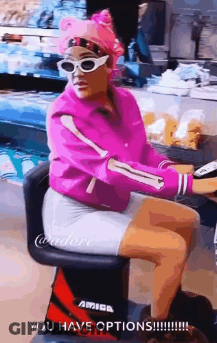 Woman In Pink Jacket And Sunglasses Sitting GIF