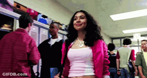 Woman In Pink Jacket And White Tank Top In Hallway GIF