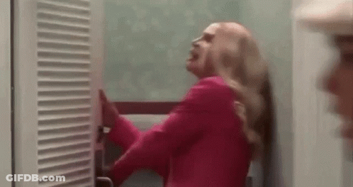Woman In Pink Jacket At Closet Door GIF