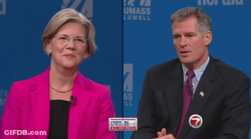 Woman In Pink Jacket Covering Mouth Man In Suit Looking On GIF