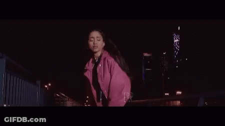Woman In Pink Jacket Dancing On Bridge At Night GIF