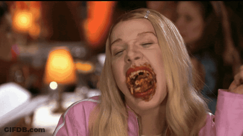 Woman In Pink Jacket Eating Spaghetti With Mouth Full GIF