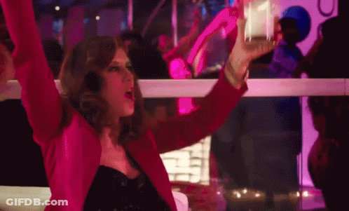 Woman In Pink Jacket Holding Glass At Club GIF