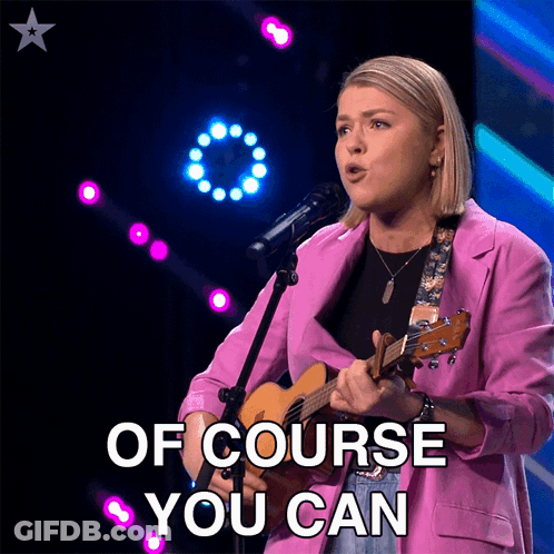 Woman In Pink Jacket Singing Into Microphone GIF