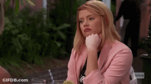 Woman In Pink Jacket Sitting At Table GIF