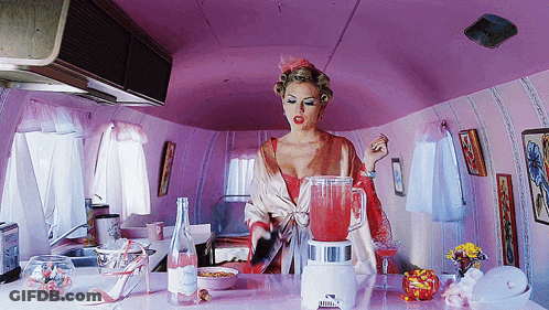 Woman In Pink Kitchen With Blender And Water GIF