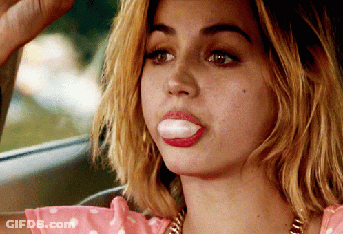 Woman In Pink Polka Dot Top Blowing Bubble Gum GIF