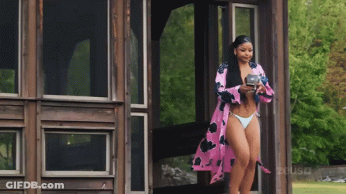 Woman In Pink Robe In Front Of Porch GIF