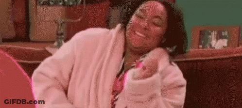 Woman In Pink Robe Sitting On Couch GIF