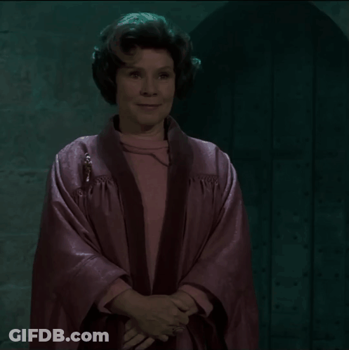 Woman In Pink Robe Smiling In Front Of Door GIF