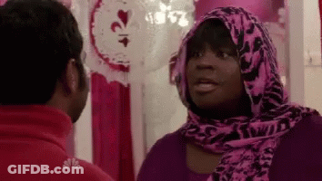 Woman In Pink Scarf Talking To Man In Red Shirt GIF