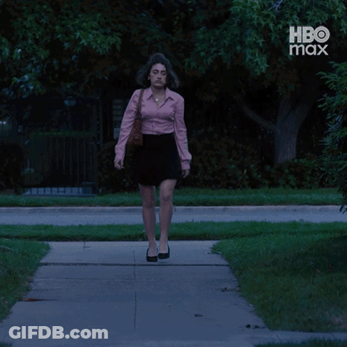 Woman In Pink Shirt And Black Skirt Walking Past HBO Max Ad GIF