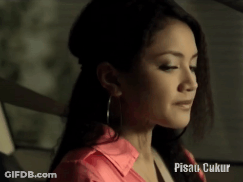 Woman In Pink Shirt And Hoop Earrings With Pisau Ukur GIF