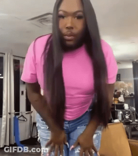 Woman In Pink Shirt And Jeans In Living Room GIF