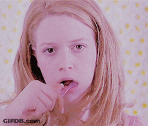 Woman In Pink Shirt Brushing Teeth GIF