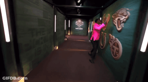Woman In Pink Shirt Dancing In Hallway With Draft GIF