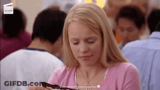 Woman In Pink Shirt Eating Chocolate In Crowded Restaurant GIF