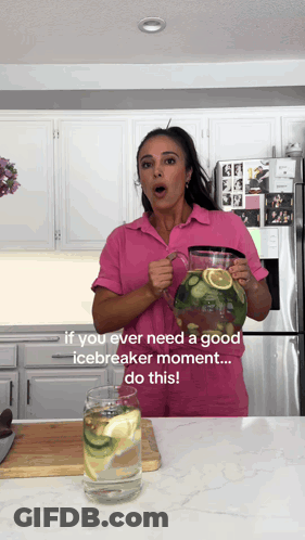 Woman In Pink Shirt Holding Lemon Cucumber Water Pitcher GIF