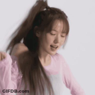 Woman In Pink Shirt Holding Ponytail Smiling GIF