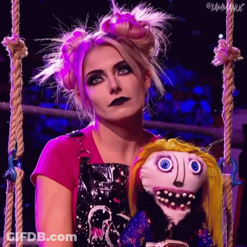 Woman In Pink Shirt Holding Stuffed Doll With Face GIF