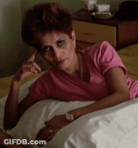 Woman In Pink Shirt Lying On Bed GIF