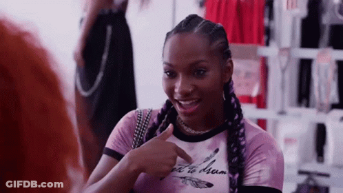 Woman In Pink Shirt Pointing And Talking To Another Woman GIF