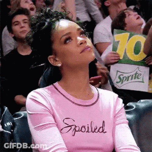 Woman In Pink Shirt Saying Spoiled Holding Sprite Sign In Crowd GIF