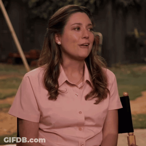 Woman In Pink Shirt Sitting In Director's Chair GIF