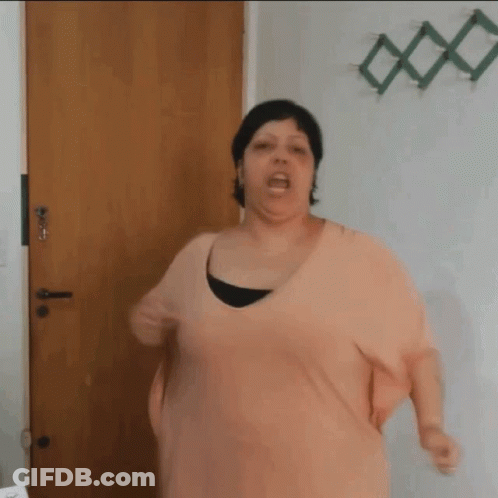 Woman In Pink Shirt Standing In Front Of Door GIF