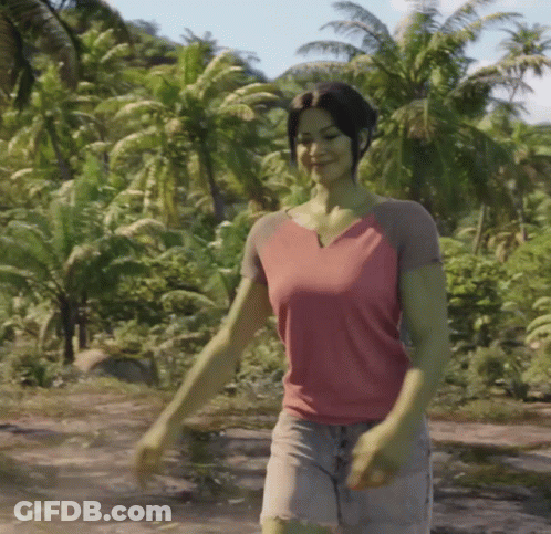 Woman In Pink Shirt Walking Through Lush Green Forest GIF