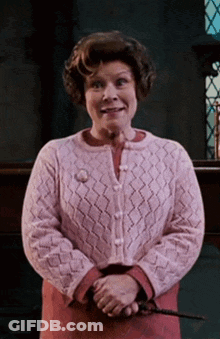 Woman In Pink Sweater Holding Wand GIF