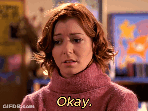 Woman In Pink Sweater Says Okay In Yellow Letters GIF