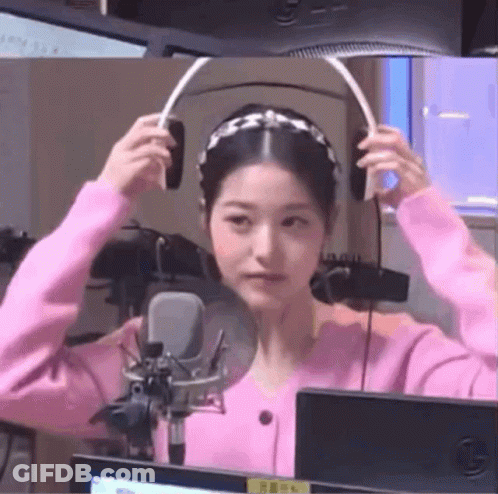 Woman In Pink Sweater Wearing Headphones GIF