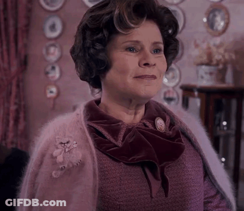 Woman In Pink Sweater With Teddy Bear Brooch GIF