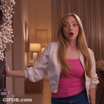 Woman In Pink Tank Top And White Jacket By Door GIF