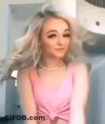 Woman In Pink Tank Top Hair Blowing In Front Of Mirror GIF