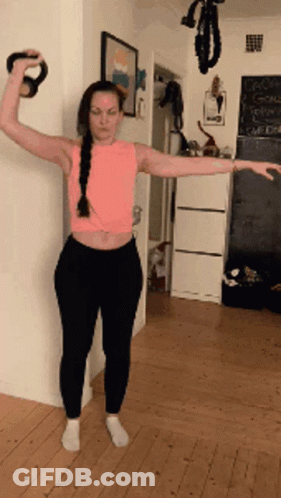 Woman In Pink Tank Top Holding Kettlebell GIF